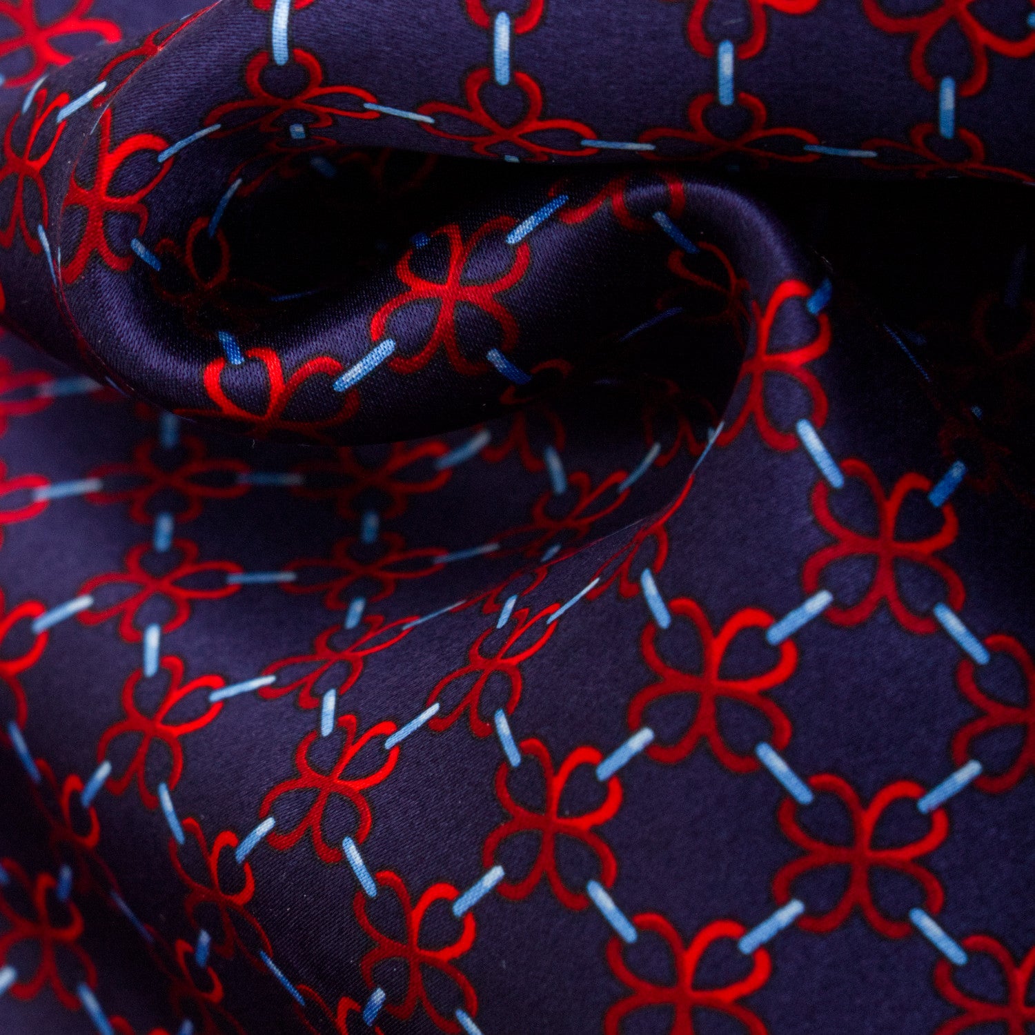 CORBATA EN SET CON PAÑUELO DE SEDA CON DIBUJOS GEOMÉTRICOS DE AZUL MARINO Y ROJO